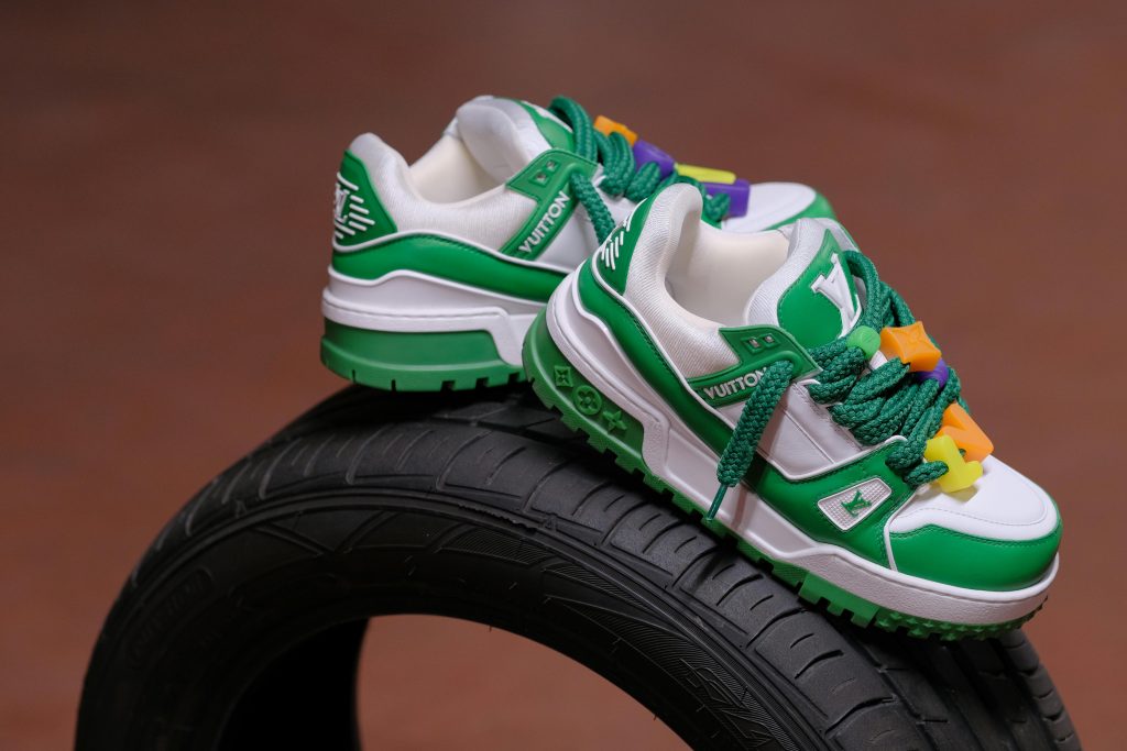 Stylish green and white sneakers artfully displayed on a tire, enhancing footwear appeal.
